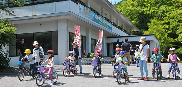 写真：サイクリングターミナルで自転車に乗る園児とそれを見守る大人