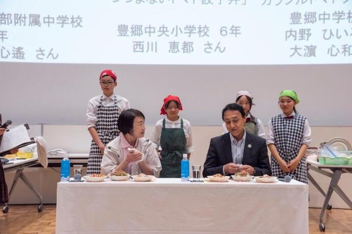 うつのみや食育フェア大森玲子実行委員長と小堀茂雄教育長による試食の様子の写真です。